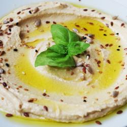 Plate of creamy hummus, drizzled with olive oil